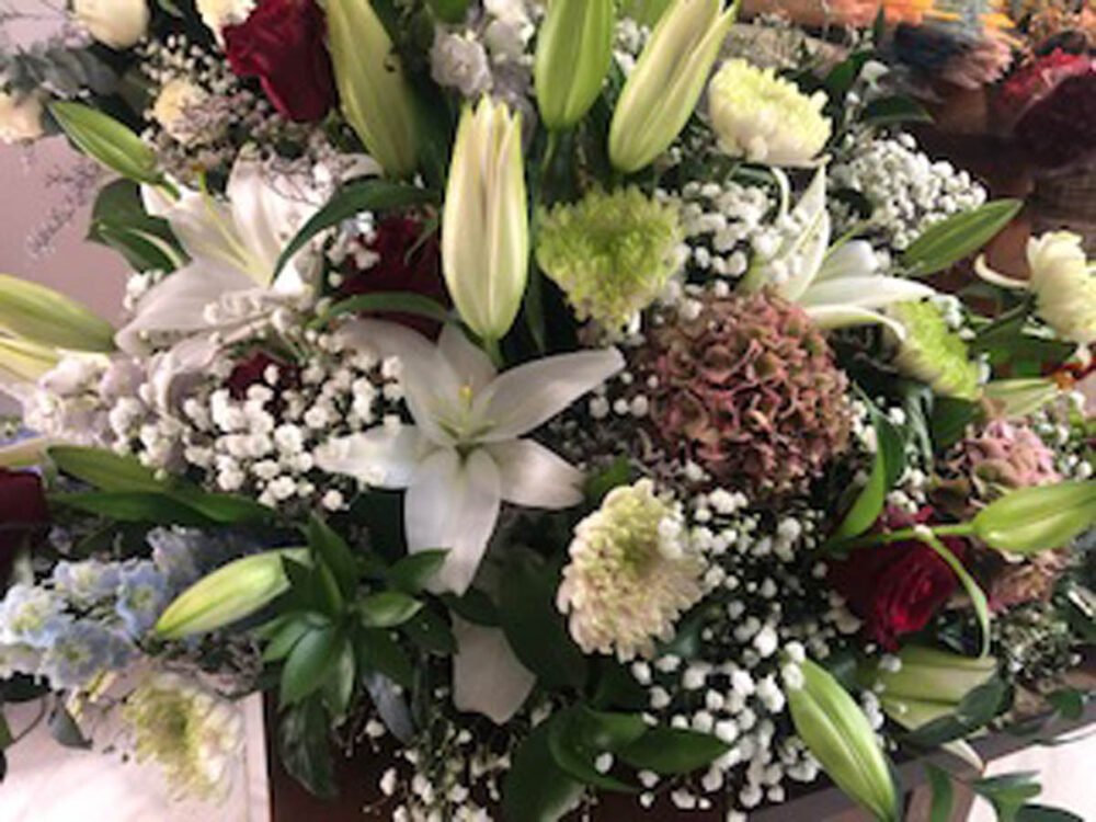 Centro con lilium oriental blanco, margaritas, hortensias, paniculata, rosas, ruscus y crisantemo